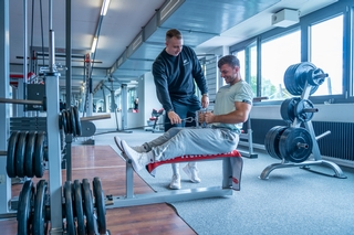 Trainer beim instruieren des engen Rudern am kabelzug von Schnell