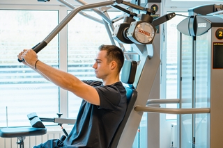 Sportler auf der Rhomboideus-Maschine von Schnell beim Training