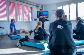 STAFF Mitglieder hören einem externen Dozent zu, während dieser die Schulungsthemen am Flipchart vorstellt.