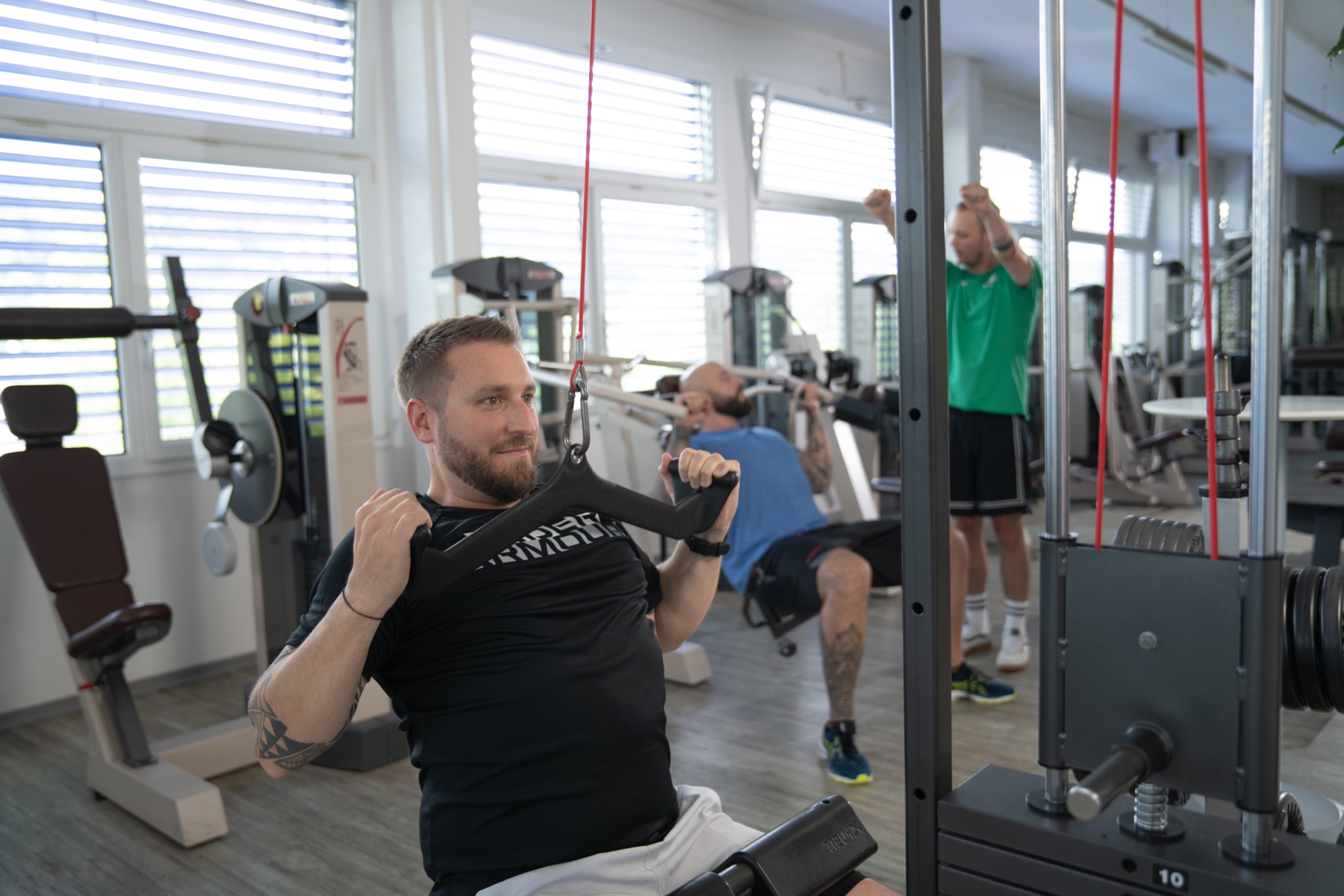 Trainierende Person beim Zirkeltraining auf einer Brust- und Rueckenmaschiene